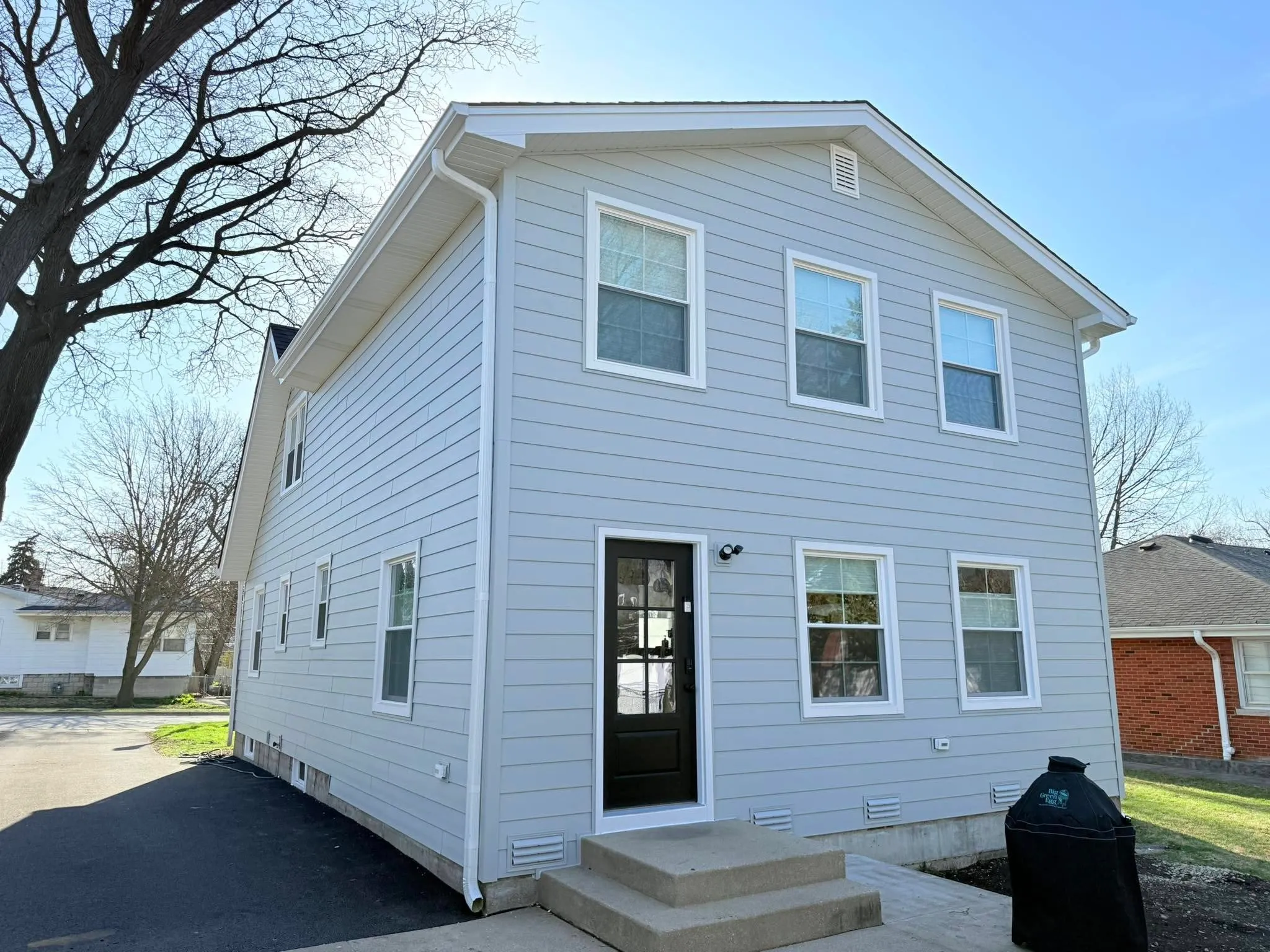 Completed white lap siding installation on a two-story home in Elmhurst, Illinois